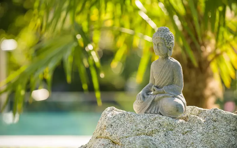 Buddhastatue aus Stein im mediterranen Garten